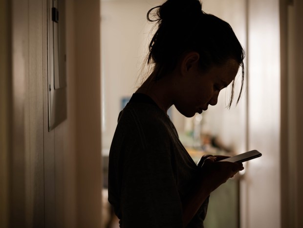 A girl checks her cell phone.(Getty Images iStockphoto)